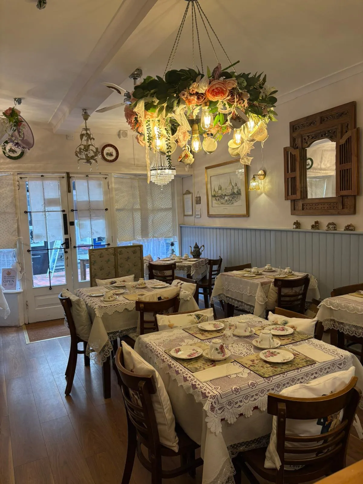 Vintage porcelain, lace tablecloths and a flower chandelier in the tearoom